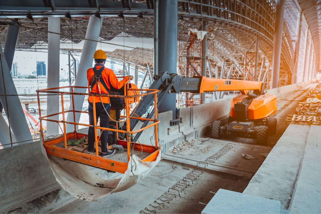 a man in an orange safety vest standing on a platform.